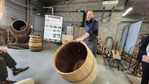 Photo by Tracey Teo. Daniel, an experienced cooper at Art du Tonneau in Beaune, France, demonstrated a barrel-making process before breaking tourists into teams for a friendly competition assembling barrels.